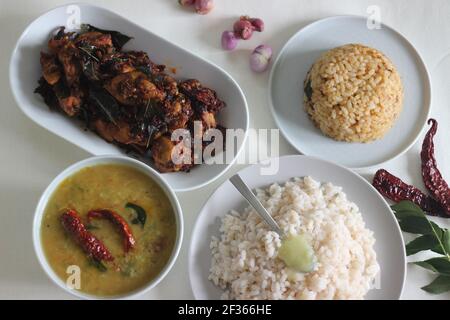 Einfache Kerala-Stil Hähnchenmahlzeiten mit Parboiled Reis und Linsen Curry. Huhn wird mit 5 Zutaten zubereitet. Aufnahme auf weißem Hintergrund Stockfoto