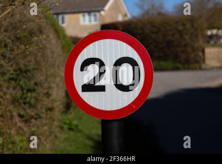 Rote kreisförmige 20 mph Meilen pro Stunde Geschwindigkeitsbegrenzung Straßenschild in Dorf, Cherhill, Wiltshire, England, Großbritannien Stockfoto