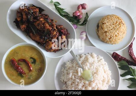 Einfache Kerala-Stil Hähnchenmahlzeiten mit Parboiled Reis und Linsen Curry. Huhn wird mit 5 Zutaten zubereitet. Aufnahme auf weißem Hintergrund Stockfoto