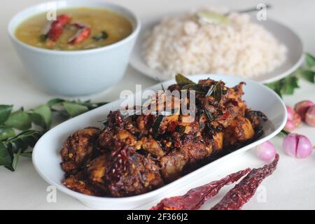 Einfache Kerala-Stil Hähnchenmahlzeiten mit Parboiled Reis und Linsen Curry. Huhn wird mit 5 Zutaten zubereitet. Aufnahme auf weißem Hintergrund Stockfoto