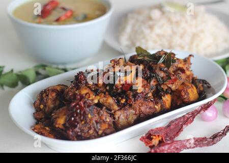 Einfache Kerala-Stil Hähnchenmahlzeiten mit Parboiled Reis und Linsen Curry. Huhn wird mit 5 Zutaten zubereitet. Aufnahme auf weißem Hintergrund Stockfoto