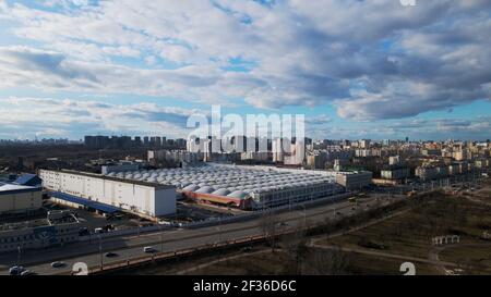 Megapolis im Frühling. Die Fabrik ist sichtbar. Um ihn herum sind hohe Stadthäuser. Stockfoto