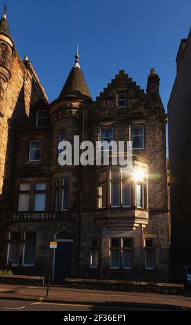 Untergehende Sonne spiegelt sich in einem Fenster des typischen Stadthauses In Edinburgh, Schottland, Großbritannien Stockfoto