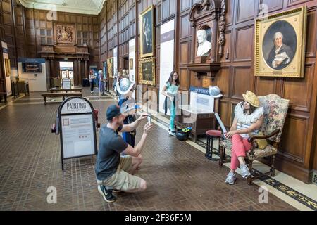 Washington DC, Folger Shakespeare Library Forschung, im Inneren der Großen Halle zeigt Gemälde Requisiten Mann fotografiert, Frau weiblich posiert, Stockfoto