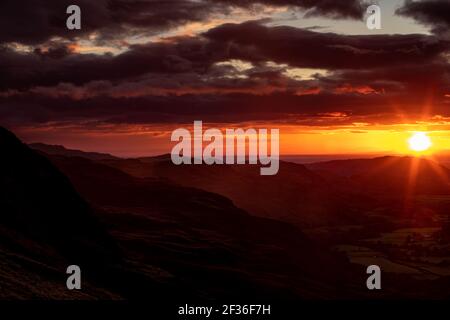 Allgemeine Ansicht Sonne erleuchtet den Horizont vom Hardknott Pass im Lake District, Cumbria. Stockfoto