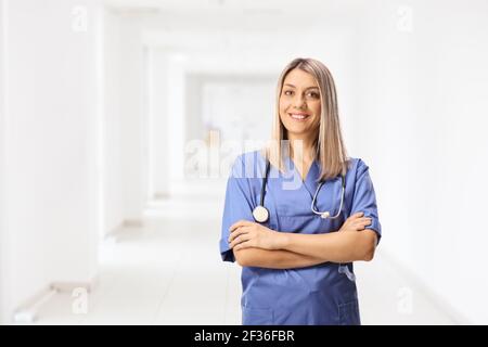Junge Krankenschwester in einer blauen Uniform posiert in einem Krankenhausflur Stockfoto
