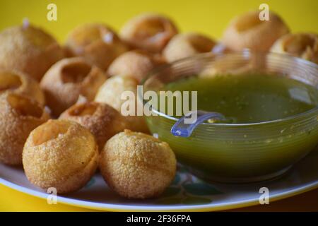 Eine selektive Fokusaufnahme eines indischen Snacks namens Panipuri Und seine Soße auf einem weißen Keramikplatte Stockfoto