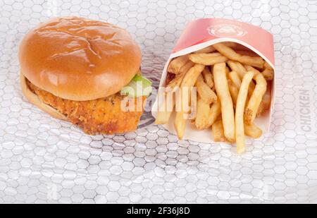 Wendy's Spicy Chicken Sandwich auf Wrapper mit Pommes frites oder Chips Stockfoto