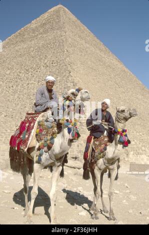 Kairo Ägypten Ägyptische Gizeh Bezirk große Pyramide von Kheops, erbaut 2600 v. Chr. Sieben Weltwunder, muslimische Männer Kamelreiter bieten Ausritte, Stockfoto