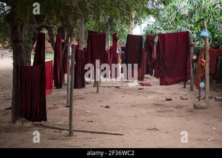 Traditionelle rote buddhistische Roben hängen an der Wäscheleine in Bagan, Nyaung-U, Myanmar Stockfoto