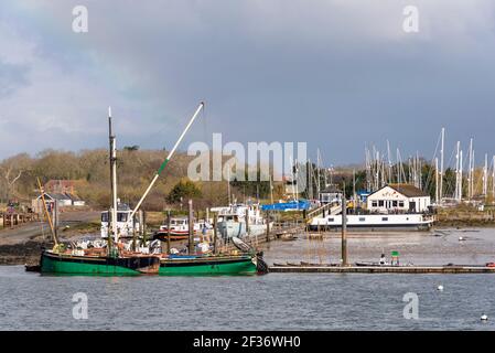 Flussufer, Bootsliegeplätze und Kai von North Fambridge auf dem Fluss Crouch, Blick von South Fambridge, Rochford, Essex, Großbritannien. Segelschiff Kitty Stockfoto