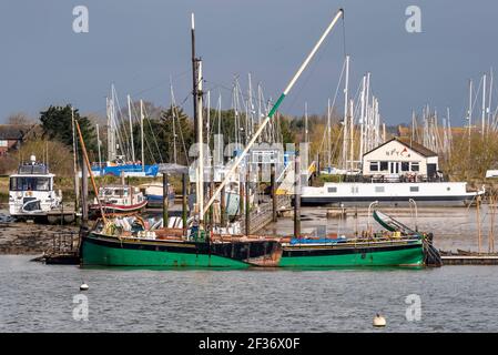 Flussufer, Bootsliegeplätze und Kai von North Fambridge auf dem Fluss Crouch, Blick von South Fambridge, Rochford, Essex, Großbritannien. Segelschiff Kitty Stockfoto