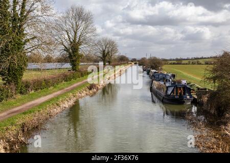 Menschen, die den Treidelpfad des Kennet- und Avon-Kanals in Hilperton mit den Kanalbooten entlang laufen. Frühling in der Nähe von Trowbridge, Wiltshire, Großbritannien Stockfoto