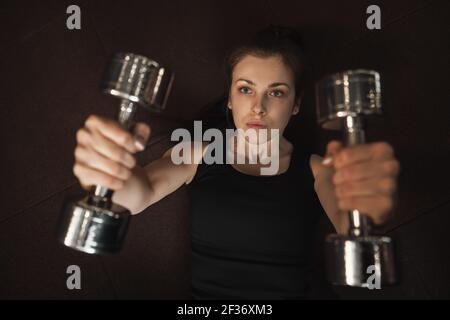 Draufsicht auf eine Sportlerin, die mit Kurzhanteln arbeitet Stockfoto