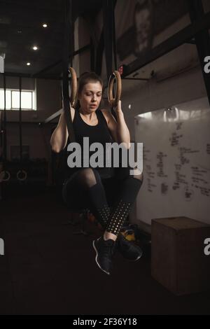 Fitness Frau tun Pull-ups auf Turnringe Stockfoto