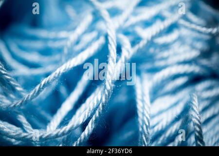 Eine extreme Nahaufnahme mit selektivem Fokus von blauen und fuzzy gebündelten Häkelfäden. Stockfoto