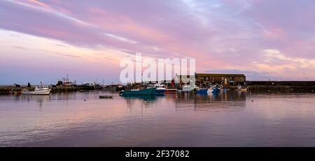 Lyme Regis, Dorset, Großbritannien. 15th. März 2021. UK Wetter: Der Abendhimmel über dem Cobb Hafen bei Lyme Regis leuchtet kurz nach Sonnenuntergang mit rosa und lila Farbtönen. Kredit: Celia McMahon/Alamy Live Nachrichten. Stockfoto