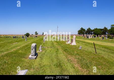 Amerikanischer Landfriedhof auf den Ebenen mit einigen Gräbern Dekoriert für Memorial Day und Ackerland in der Ferne Stockfoto