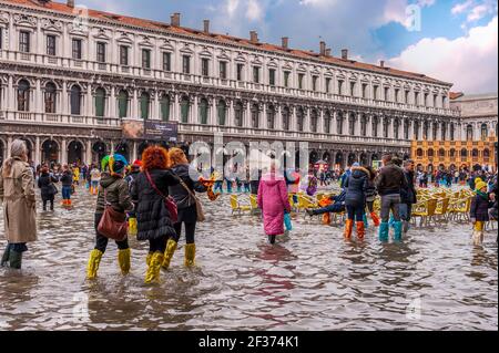 Touristen auf dem Markusplatz während einer Episode von Aqua Alta in Venedig in Venetien, Italien Stockfoto