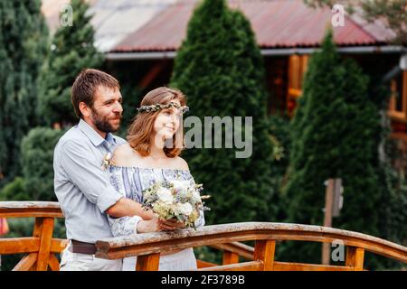 Eclectic rustikalen Hochzeitspaar stehen auf der Brücke Stockfoto