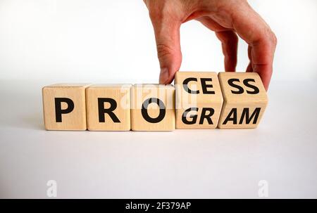 Prozess- und Programmsymbol. Geschäftsmann dreht Holzwürfel und ändert das Wort "Programm" in "Prozess". Schöner weißer Hintergrund. Geschäft, Prozess Stockfoto