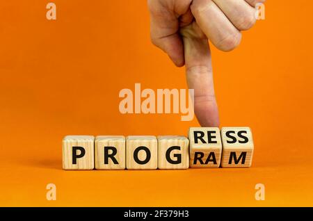 Fortschritts- und Programmsymbol. Geschäftsmann dreht Holzwürfel und ändert das Wort "Programm" in "Fortschritt". Schöner orangefarbener Hintergrund. Geschäft, Progr Stockfoto