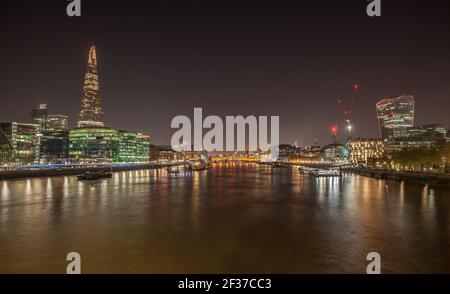 Ein faszinierender Blick auf schöne Gebäude mit bunten Lichtern reflektiert Auf dem Wasser in London Stockfoto