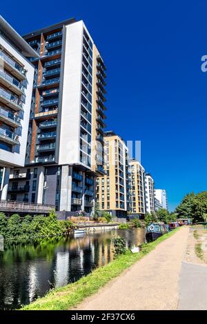 Neu erbautes Wohngebäude mit Turmuhren entlang des Regent's Canal in Mile End, London, Großbritannien Stockfoto