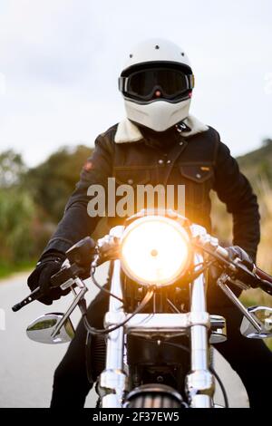 Low-Angle-Ansicht eines Motorrads steht auf der Straße Mit seinem Besitzer allein Stockfoto
