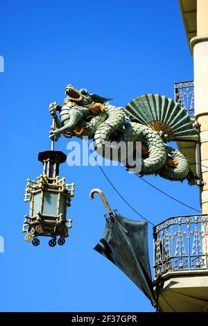 Barcelona. Chinesischer Drache mit Laterne und Schirm gegen blauen Himmel. Jugendstil-Dekoration Detail des Gebäudes auf La Rambla Straße. Stockfoto