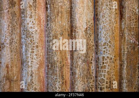 Detail einer farbigen Stuckwand mit angehoben und rissig Vertikale Streifen Stockfoto