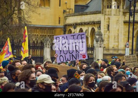 Ein Demonstrator hält am Reclaim auf dem Parliament Square ein Schild mit der Aufschrift „Police Your Own“. In London versammelten sich Menschenmengen, um gegen die heftige Reaktion der Polizei auf die Mahnwache von Sarah Everard sowie gegen das neue Gesetz der Regierung über Polizei, Verbrechen, Verurteilung und Gerichte zu protestieren, das der Polizei neue Befugnisse geben würde, um mit Protesten umzugehen. London, Großbritannien 15. März 2021. Stockfoto
