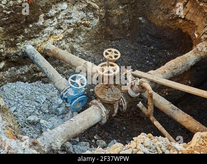 Alte Stadt Wasser Haupthähne, ein Loch gegraben, um zu reparieren oder ersetzen Wasserversorgungseinheiten Stockfoto
