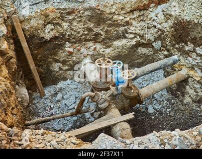 Alte Stadt Wasser Haupthähne, ein Loch gegraben, um zu reparieren oder ersetzen Wasserversorgungseinheiten Stockfoto