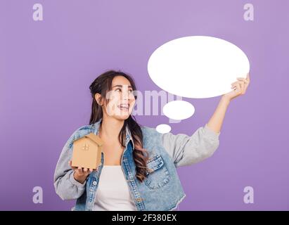 Happy Asian Portrait schöne nette junge Frau tragen Denim aufgeregt lächelnd halten Haus Modell und leere Rede Blase Zeichen, Studio erschossen auf schnurrem isoliert Stockfoto