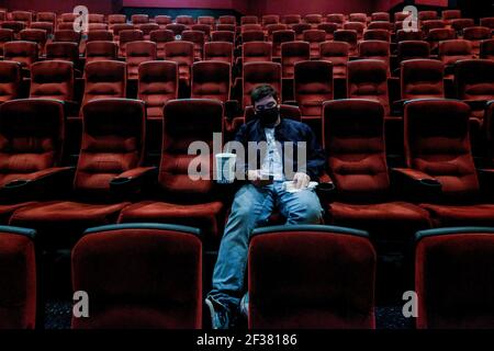 Los Angeles, Kalifornien, USA. März 2021, 15th. Ein Oviegoer, der am ersten Tag der Wiedereröffnung in einem sozial fernen Sitzungssaal im AMC Theatre sitzt, nachdem er am 15. März 2021 wegen der COVID-19-Pandemie in Burbank, Kalifornien, geschlossen wurde. Los Angeles County Restaurants können wieder begrüßen Kunden in Innenräumen, und Kinos und Fitness-Center sind in der Lage, wieder zu öffnen, alle mit begrenzter Kapazität, mit der Grafschaft rückt heute in die weniger restriktive rote Stufe des Staates ''Blueprint für eine sichere Wirtschaft. Kredit: Ringo Chiu/ZUMA Wire/Alamy Live Nachrichten Stockfoto