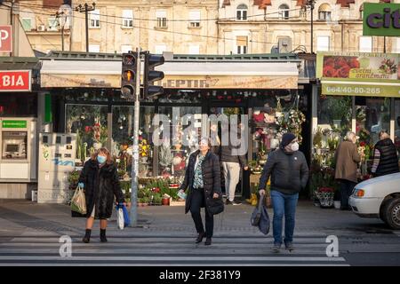 BELGRAD, SERBIEN - 12. DEZEMBER 2020: Menschen, alte Frauen und ein jüngerer Mann warten auf einer Straße in Belgrad einige mit Gesichtsmaske Schutzausrüstung, so Stockfoto