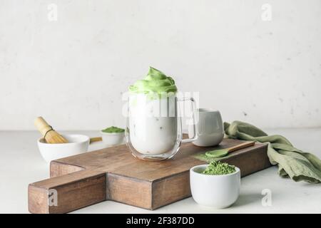 Komposition mit leckeren dalgona Matcha Latte auf hellem Hintergrund Stockfoto
