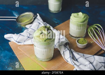 Zusammensetzung mit leckeren dalgona Matcha Latte auf dem Tisch Stockfoto