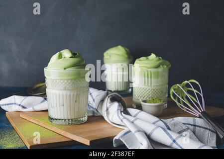 Komposition mit schmackhaftem Dalgona Matcha Latte auf dunklem Hintergrund Stockfoto