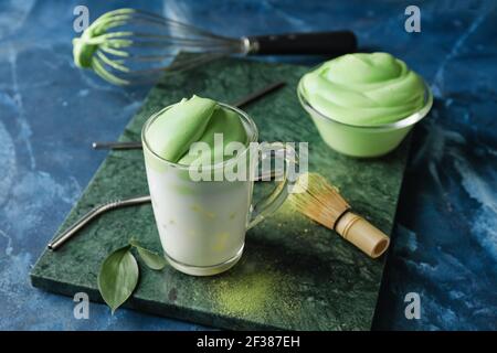 Komposition mit leckeren dalgona Matcha Latte auf farbigem Hintergrund Stockfoto