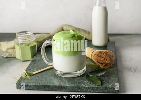 Zusammensetzung mit leckeren dalgona Matcha Latte auf dem Tisch Stockfoto