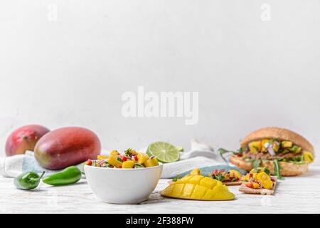 Komposition mit frischer Mango-Salsa auf hellem Holzhintergrund Stockfoto