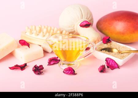 Zusammensetzung mit ätherischem Mango-Öl und Badezubehör auf Farbe Hintergrund Stockfoto