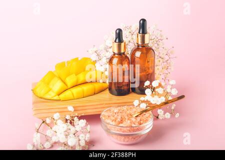 Komposition mit ätherischem Mangoöl und Meersalz auf Farbe Hintergrund Stockfoto