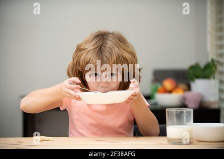 Kaukasische Kleinkind Kind Junge essen gesunde Suppe in der Küche. Kinderernährung. Stockfoto