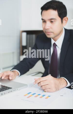 Handsome asiatischen Geschäftsmann arbeitet im Büro mit Laptop-Computer und Dokumente auf dem Tisch - Hand konzentriert, weichen Ton Stockfoto