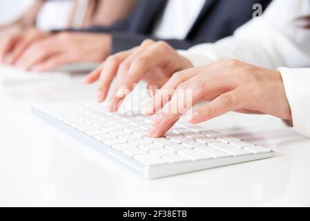 Hände tippen auf Computertastaturen Stockfoto