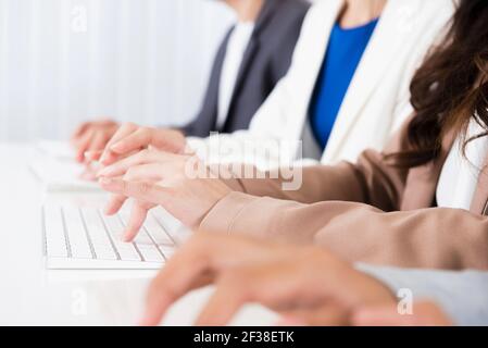 Geschäftsleute tippen mit der Hand auf Computertastaturen Stockfoto