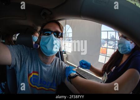 Ein Mann erhält einen Covid-19-Schuss auf einer Sutter Health-Fahrt durch die Impfstelle in Santa Cruz, Kalifornien. März 2021 Stockfoto